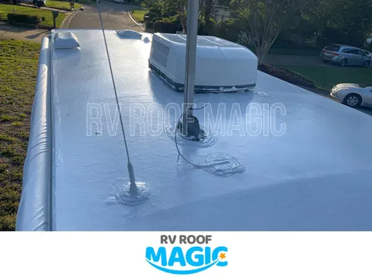 White RV roof coated with waterproof sealant showing vents and antenna after protective roof coating application.